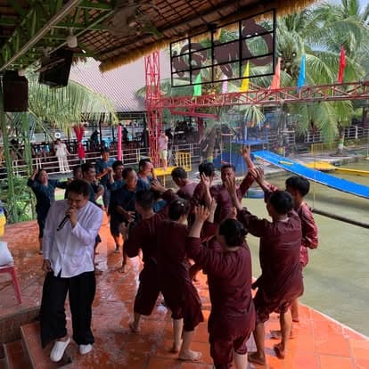 Đoàn khách áo nâu hò reo chơi trò chơi dân gian dưới mái che tại Làng du lịch sinh thái Ông Đề