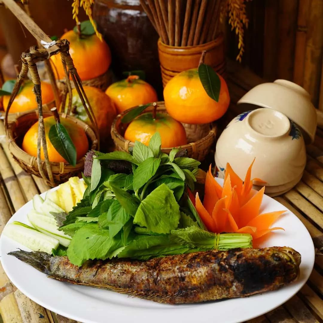 Đĩa cá lóc nướng ăn kèm rau thơm, dưa leo và cà rốt tỉa hoa
